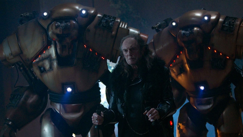 David Bradley's character surrounded by two robots