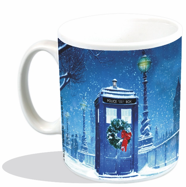 Image of blue mug with TARDIS image on it in a snowy setting with a Christmas wreath on the door