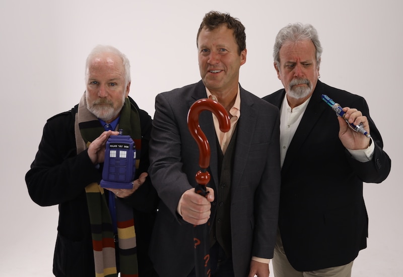 Image of Michael J Nelson holding a toy TARDIS, Kevin Murphy holding an umbrella and Bill Corbett holding a sonic screwdriver