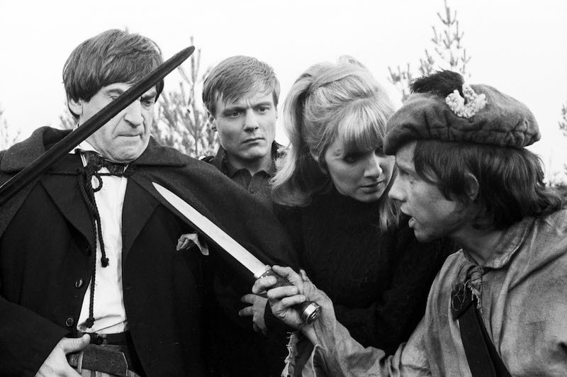 Black and white photo of the doctor being confronted by the highlanders