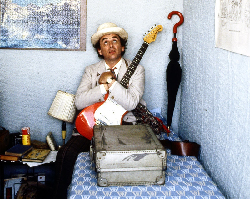 The Seventh Doctor holding an electric guitar