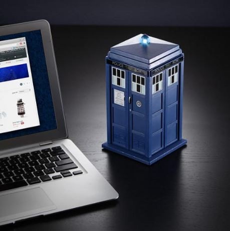 Image of a blue wireless speaker in the shape of the TARDIS next to a laptop