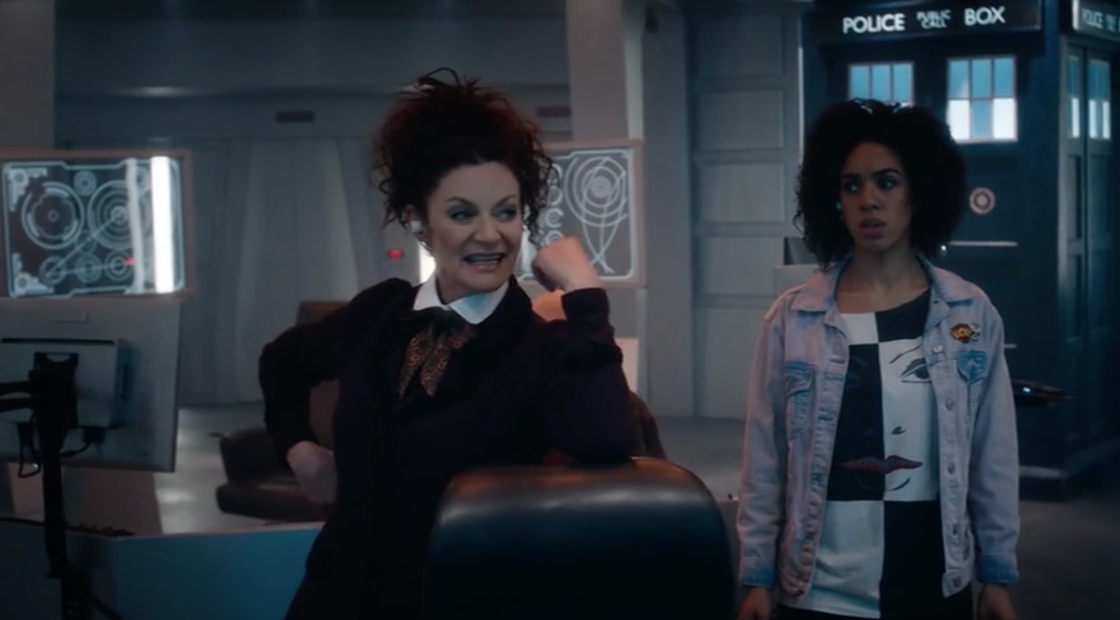 Image of a smiling Missy next to Bill Potts with the TARDIS behind them